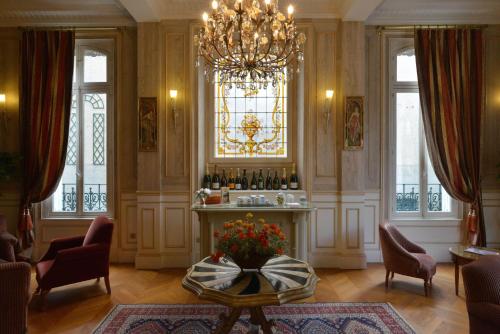 a living room with a table and a chandelier at Hotel Castel Jeanson in Ay