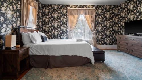 a bedroom with a bed and a dresser and a television at Governor's Mansion beautiful 3bd with pool table in Leadville