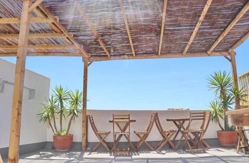 a patio with chairs and tables under a roof at Complejo La Chanca, HAB 11 in Conil de la Frontera