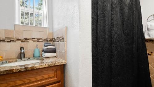 a bathroom with a sink and a shower curtain at 1880s Victorian Remodel - 1 2 block from downtown in Leadville