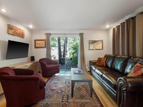a living room with a leather couch and a table at Relaxing 2 Bedroom steps from Vail Resort in Vail