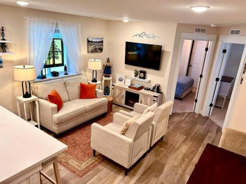 a living room with two couches and a flat screen tv at Leadville's Copper Top Getaway in Leadville