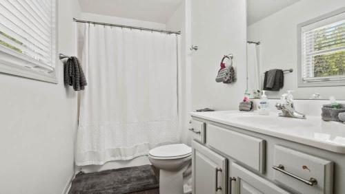 a white bathroom with a toilet and a sink at Mountain Home with Amazing Views and Hot Tub in Leadville