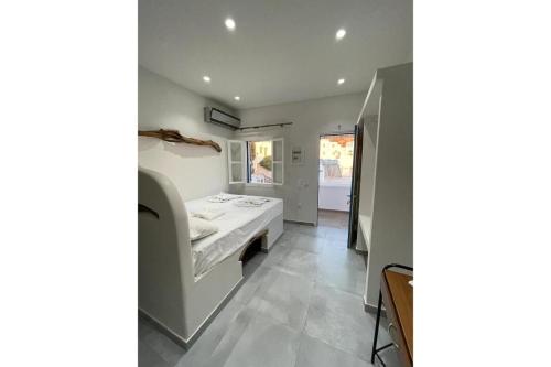 een badkamer met een bed in een kamer bij Politimis Studio N2 in Amorgós