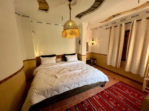 a bedroom with a bed and a chandelier at Grand Canyon Lodge Dades in Aït Idaïr