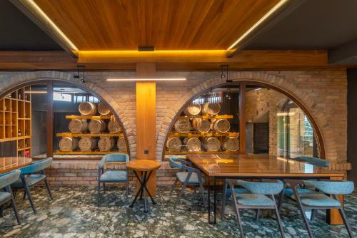 a dining room with a table and chairs and a brick wall at Dve Kule Resort & Winery in Bačinci
