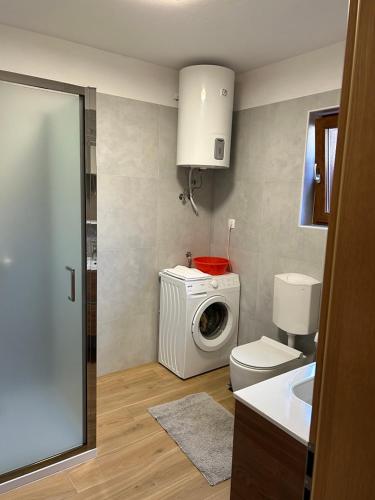 a bathroom with a washing machine and a washer at Apartment Pejic in Umag