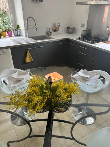 - une cuisine avec une table ornée de fleurs jaunes dans l'établissement Maison Dream in Marciac, à Marciac