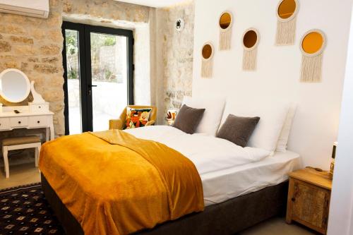 una camera da letto con un letto con una coperta gialla sopra di Galathea House a Kotor (Cattaro)