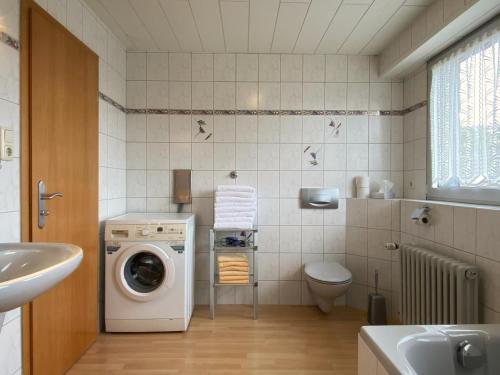 a bathroom with a washing machine and a toilet at Hotel-Restaurant-Haus Berger in Viersen