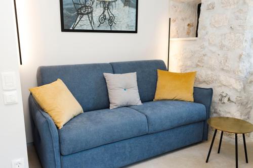 a blue couch with yellow pillows in a living room at Galathea House in Kotor