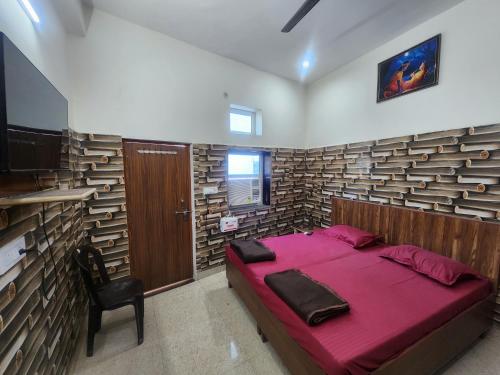 1 dormitorio con 1 cama y 1 silla en Radha Rani Dham (Near Iskcon Temple) en Vrindāvan