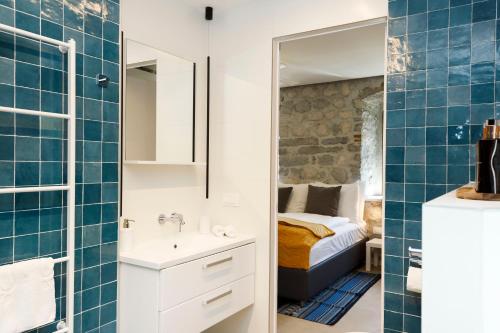 a bathroom with a sink and a bed in a room at Galathea House in Kotor