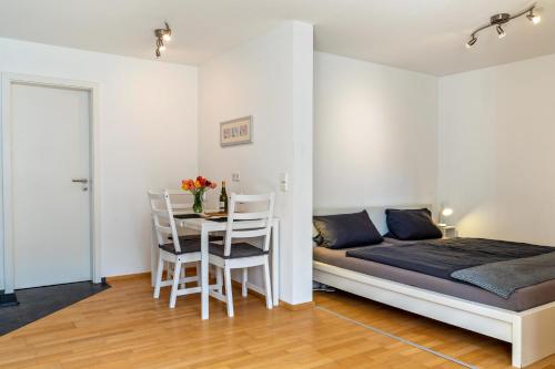 Un dormitorio con una cama y una mesa con sillas. en Ferienwohnung Lehen - Herr 1, en Freiburg im Breisgau