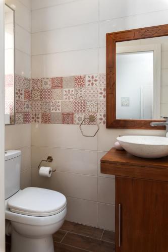 a bathroom with a toilet and a sink and a mirror at Family-Friendly Spacious Townhouse with Garden - Close to Airport in Gudja