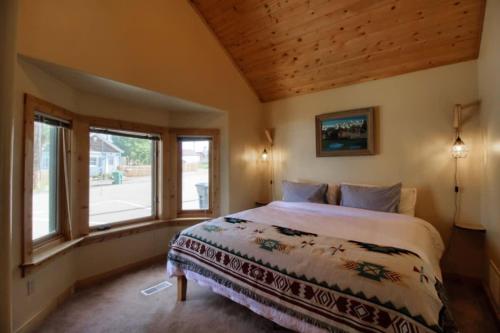 a bedroom with a bed and a large window at Little Lodge Leadville: charming 2bd in Leadville