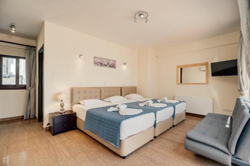 a bedroom with two beds and a chair at Seafront Protaras Villas in Protaras