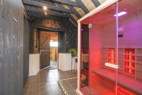- Entrada a un spa con luces rojas en un edificio en Barraston Farm Country Retreat en Balmore