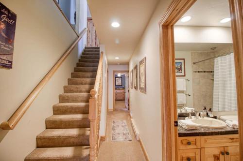 a staircase leading to a bathroom with a sink and a tub at Unit 520 - 3br condo with balcony views in Avon