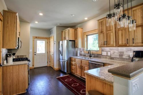 a kitchen with wooden cabinets and a stainless steel refrigerator at Modern 3bd cabin in Edgewater in Granby