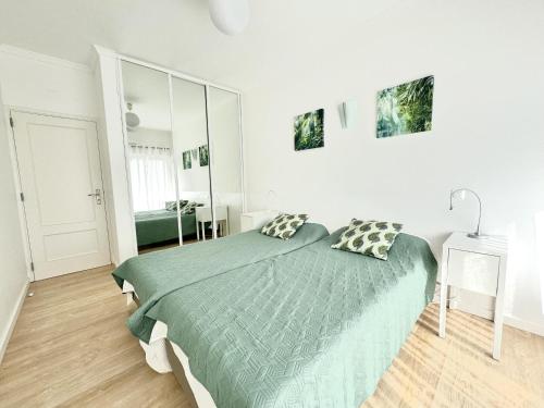 ein Schlafzimmer mit einem Bett mit einer grünen Bettdecke in der Unterkunft Apartamento Terra Mare by Seewest in Lagos
