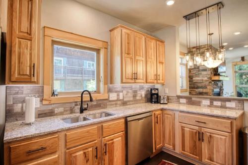 a kitchen with wooden cabinets and a sink and a window at Modern 3bd cabin in Edgewater in Granby