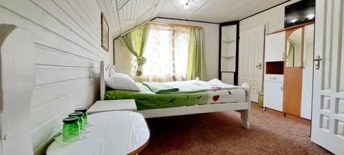 Kleines Zimmer mit einem Bett und einem Tisch in der Unterkunft Villa Girska Sonata in Mykulytschyn