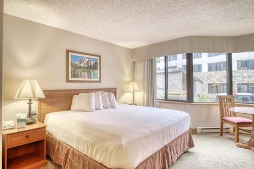 a bedroom with a large bed and a large window at Studio #120 @ Perfect Location w Pool & Hot Tub in Crested Butte