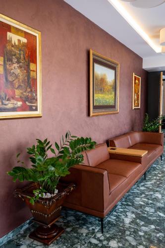 a living room with a brown couch in a room at Dve Kule Resort & Winery in Bačinci
