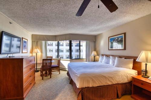 een slaapkamer met een bed, een bureau en een raam bij NEW Listing Perfect Location 414 with Heated Pool and Hot Tub in Crested Butte