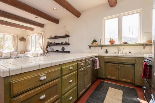 a large kitchen with wooden cabinets and a sink at Renovated Lodge - Room 3 with pool access in Joshua Tree