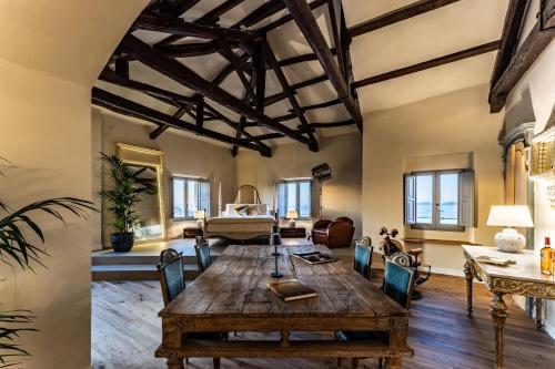 a living room with a wooden table and chairs at Palazzo Boyl 1840 in Cagliari