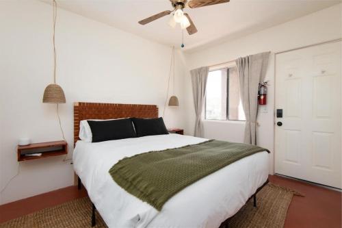 sypialnia z dużym łóżkiem i wentylatorem sufitowym w obiekcie Renovated Lodge - Room 3 with pool access w mieście Joshua Tree