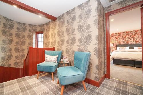 een slaapkamer met een bed en een blauwe stoel bij Barraston Farm Country Retreat in Balmore