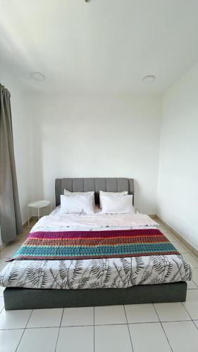 a bed with a colorful blanket on it in a room at MUJI Cosy Level 25th Room Amber Residence @ Quayside Mall Rimbayu Near to Masha Oasis Tenby KLIA Kota Kemuning in Teluk Panglima Garang