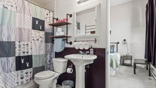 a bathroom with a sink and a toilet and a mirror at Beautiful Mountain Views in Iconic Building in Leadville