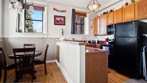 a kitchen with a table and a black refrigerator at Papa's Place - blocks from downtown in Leadville