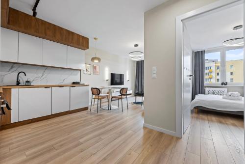 a kitchen and living room with a table and a bed at RentPlanet - Apartament Międzynarodowa in Warsaw