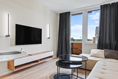 a living room with a couch and a tv at RentPlanet - Apartament Międzynarodowa in Warsaw