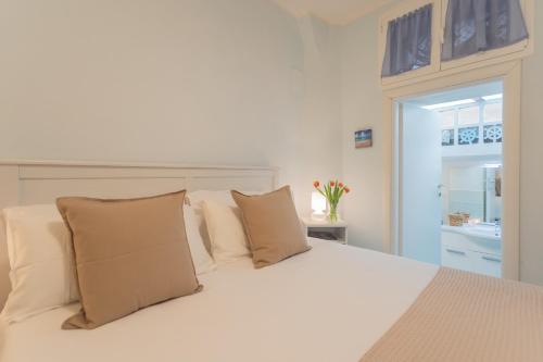 a white bed with pillows in a bedroom at Il Timone by Rent All Como in Colonno