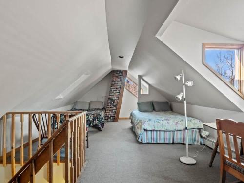 a attic bedroom with a bed and a staircase at Painted Lady in Leadville