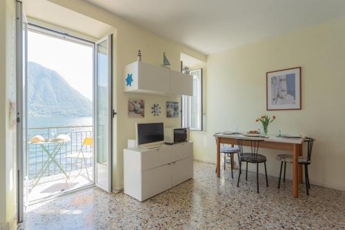 a room with a desk with a computer and a table at Il Timone by Rent All Como in Colonno