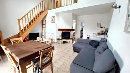 un salon avec un canapé bleu et une table dans l'établissement Maison avec jardin à Sigean - Confort et tranquillité, à Sigean