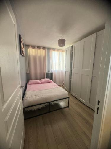 Cette petite chambre comprend un lit avec des draps roses. dans l'établissement Appartement proche aéroport, à Marignane