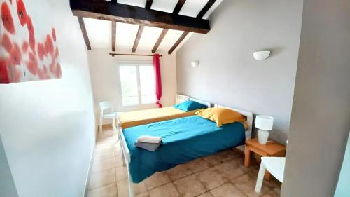 une chambre avec un lit bleu et une fenêtre dans l'établissement Maison avec jardin à Sigean - Confort et tranquillité, à Sigean