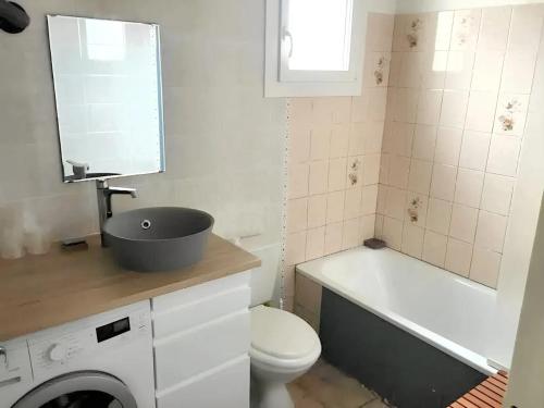 une salle de bain avec un lavabo, des toilettes et une baignoire dans l'établissement Maison avec jardin à Sigean - Confort et tranquillité, à Sigean