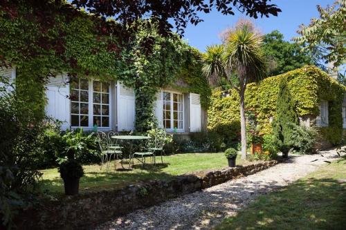 une maison avec une table et des chaises dans la cour dans l'établissement Les Bleuets, à Saint-Malo