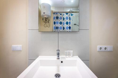 uma casa de banho com um lavatório branco e um espelho. em Sunny Apartment Blije Rust em Dorp Sint Michiel