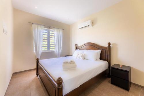 um quarto com uma cama com lençóis brancos e uma janela em Sunny Apartment Blije Rust em Dorp Sint Michiel