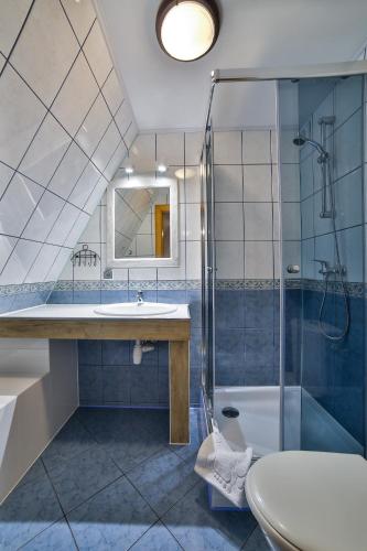 a bathroom with a sink and a shower and a toilet at Śwarna Wynajem Pokoi in Zakopane